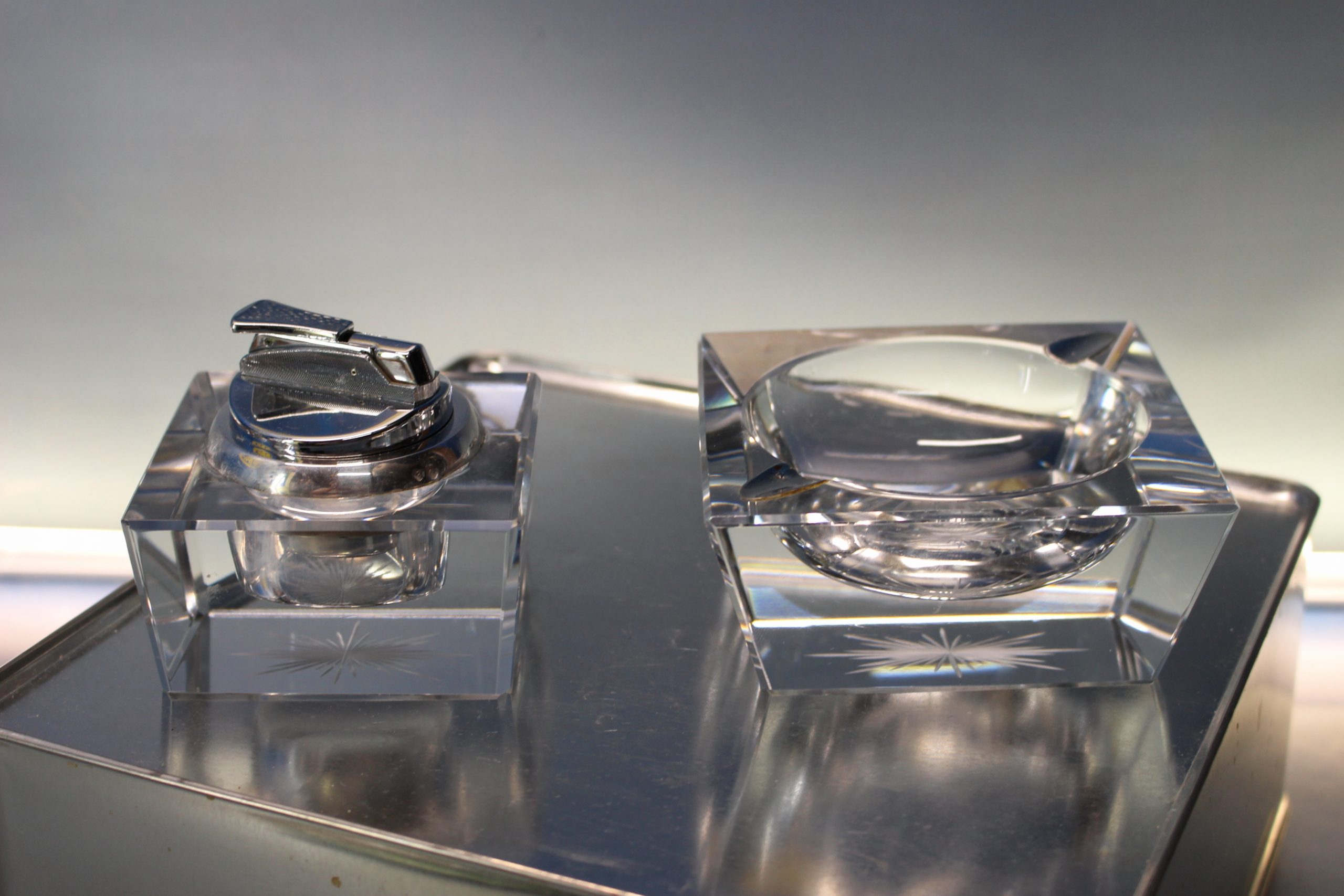 Juego de cenicero y mechero de mesa en cristal tallado y plata.