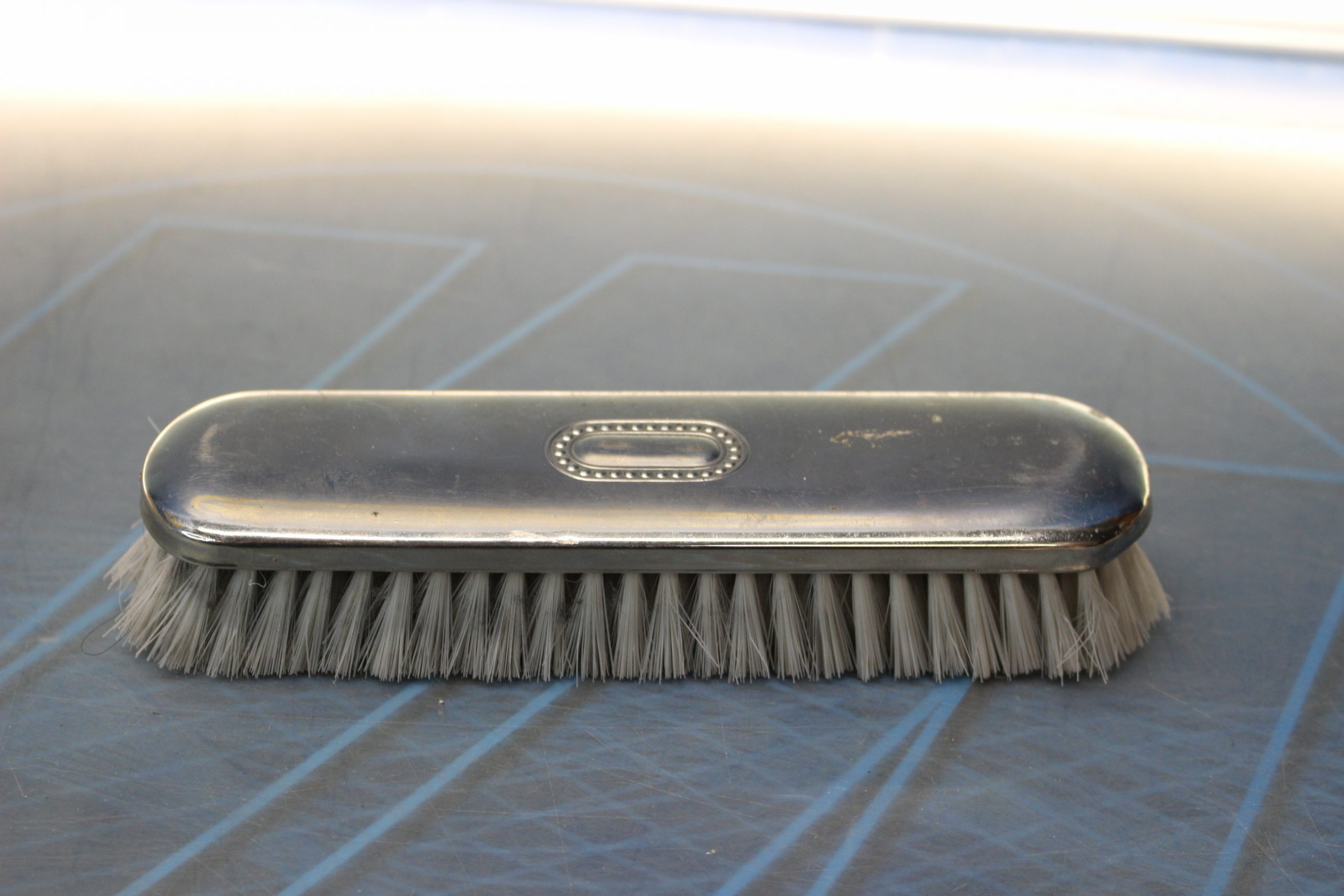 Cepillo para ropa forrado en metal plateado.