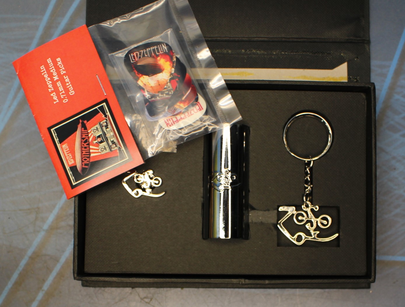 Led Zeppelin. Zoso caja con pin, llavero y slide. + Bolsa de 9 puas Mothership