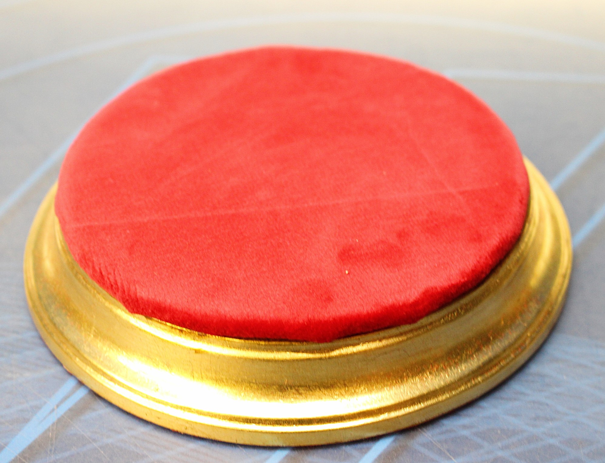 Peana circular de madera dorada y terciopelo.