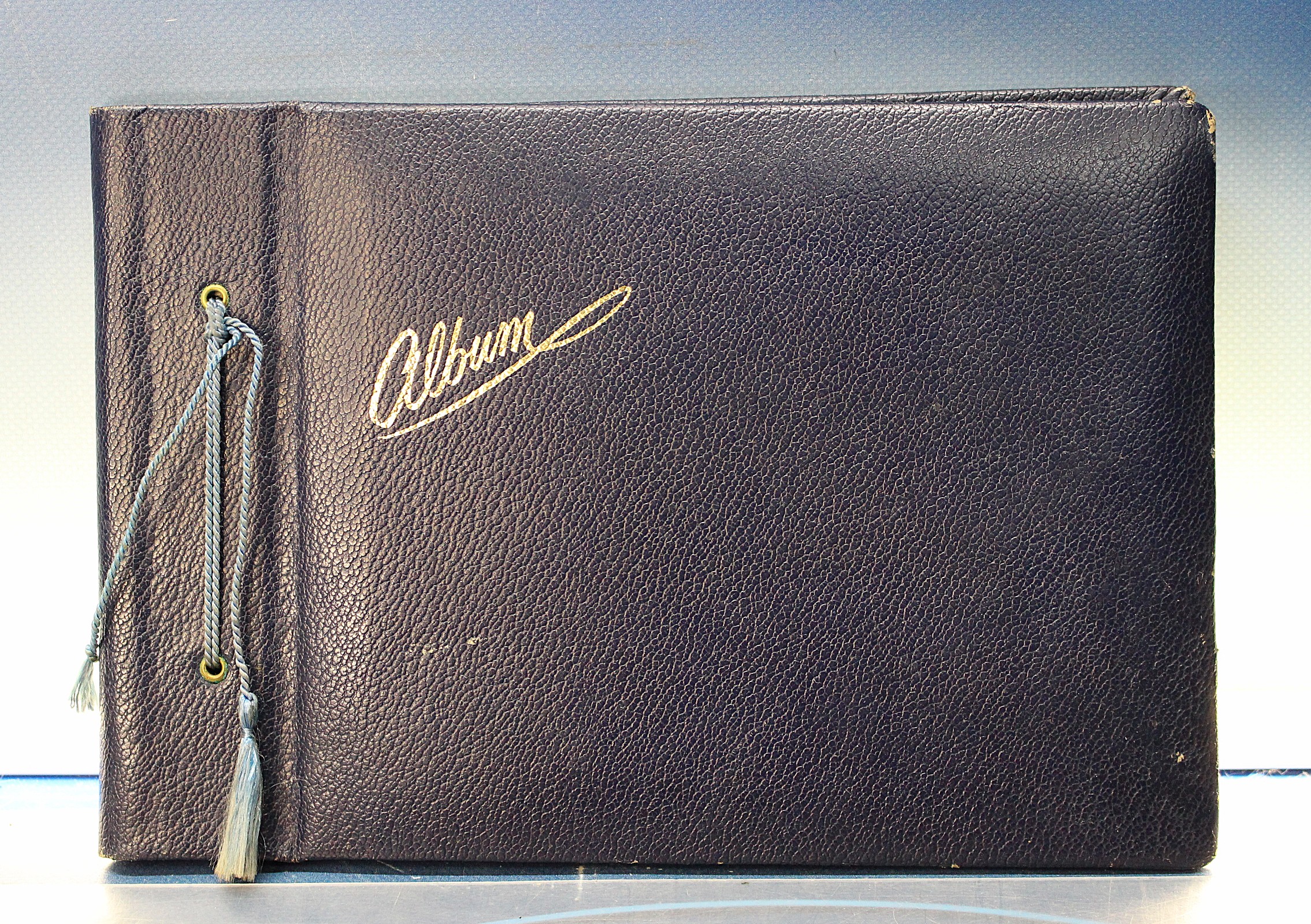 Antiguo álbum fotográfico azul oscuro y dorado.