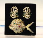 Conjunto de broche y pendientes en metal dorado y cristales.