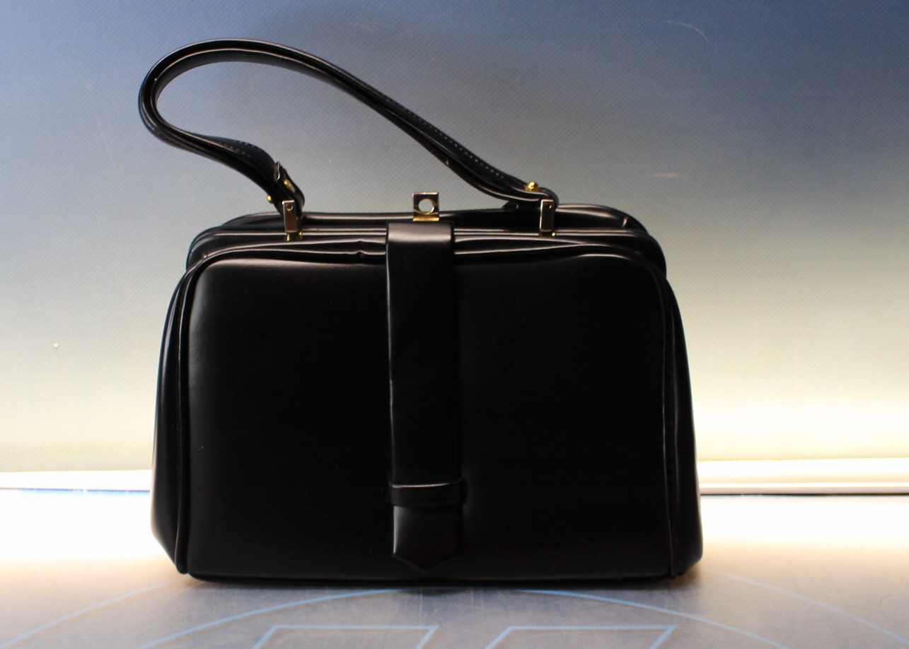 Bolso de mano vintage. Cuero o símil negro con metal dorado.