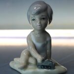 Porcelana Casades: Figura de bebé con tren. Vintage.