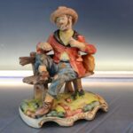 18. Mendigo comiendo patata. Figura de porcelana biscuit.