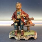 19. Mendigo comiendo sopa. Figura de porcelana biscuit.